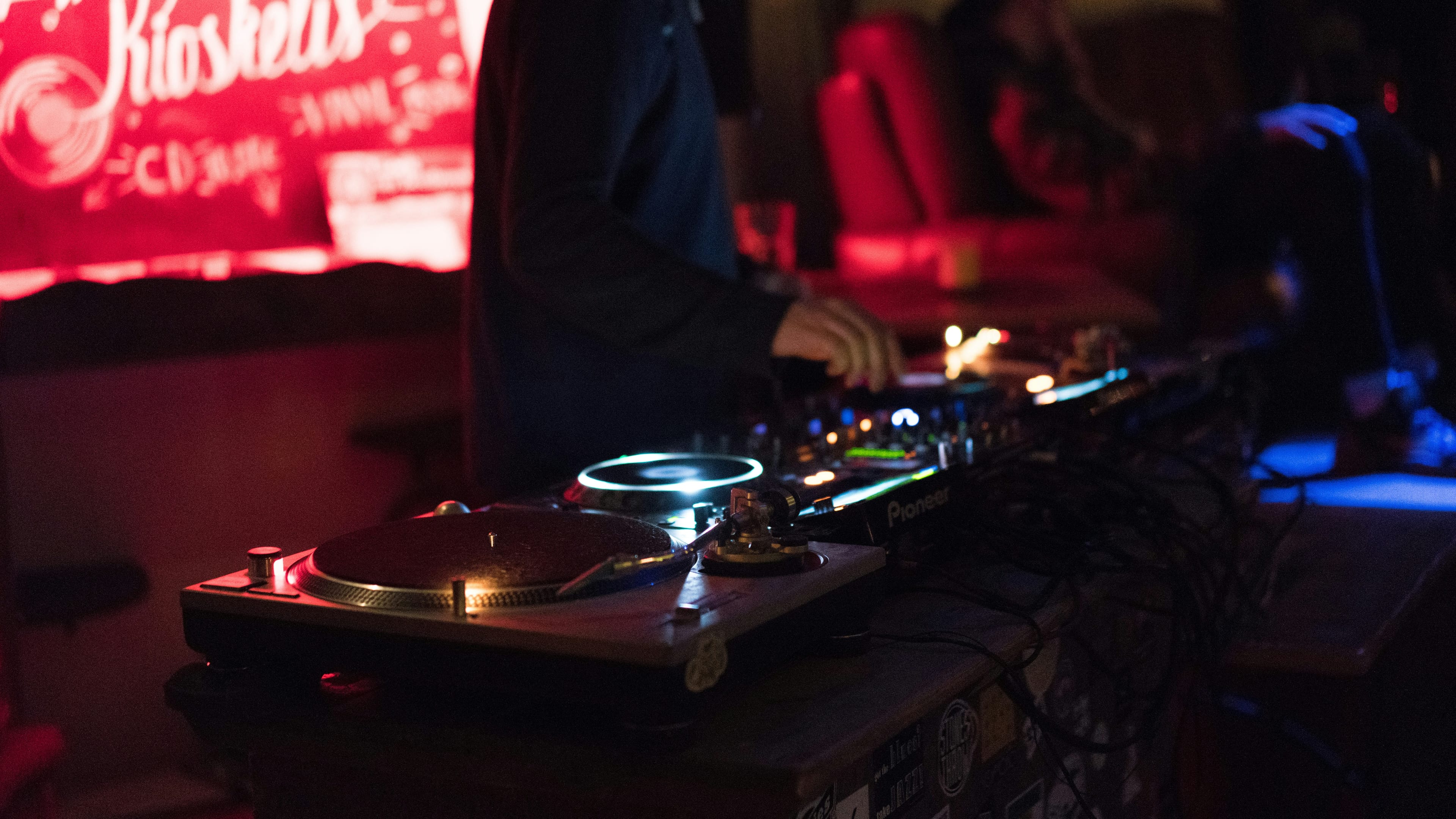 DJ decks and a packed dance floor under club lighting